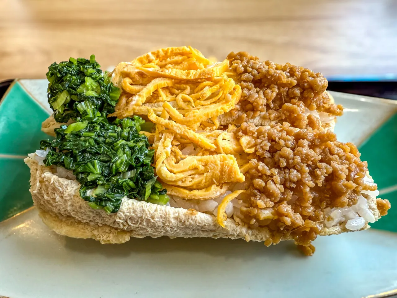 まかない仕立ての一品。青菜・卵・豚そぼろの3色トッピングが並ぶ。